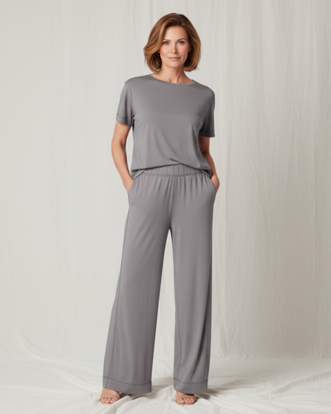 Woman wearing a gray outfit with wide-leg pants on a white background